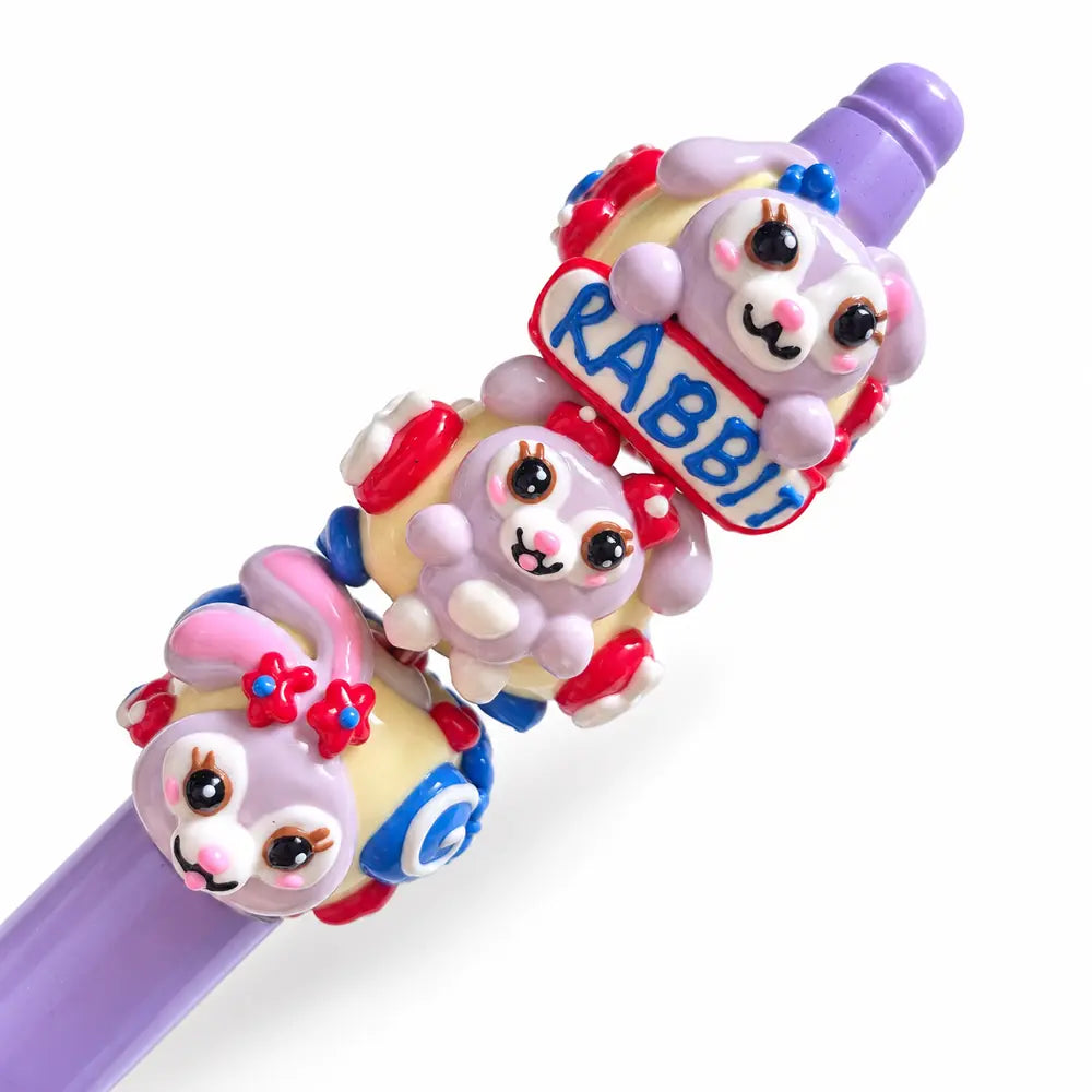 Ten hand-painted acrylic beads with lavender bunny designs, pale yellow bases, red hearts and blue flower details.