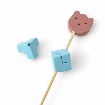 Blue acrylic puzzle bead piece beside a matching assembled square on a display rod.
