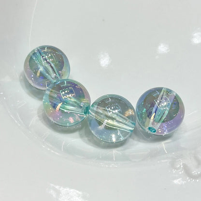 Four transparent blue acrylic round beads with iridescent reflections and visible through-holes.