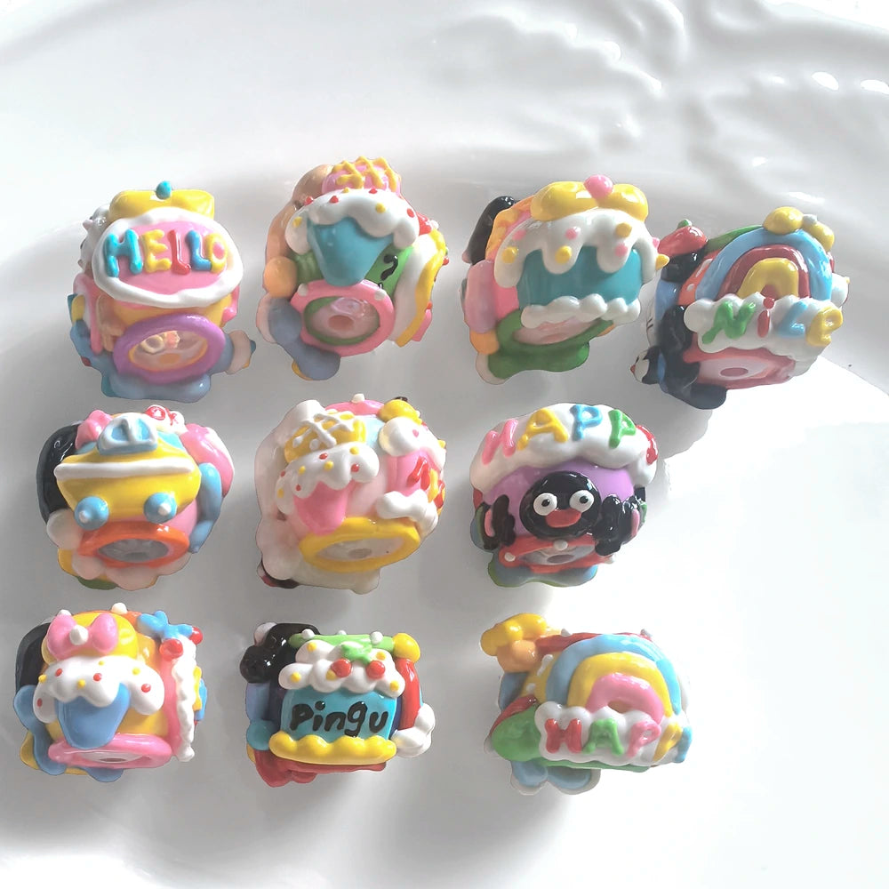 Back view of 10 hand-painted acrylic beads with raised rainbow, cupcake, bow and lettering details.