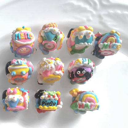 Back view of 10 hand-painted acrylic beads with raised rainbow, cupcake, bow and lettering details.