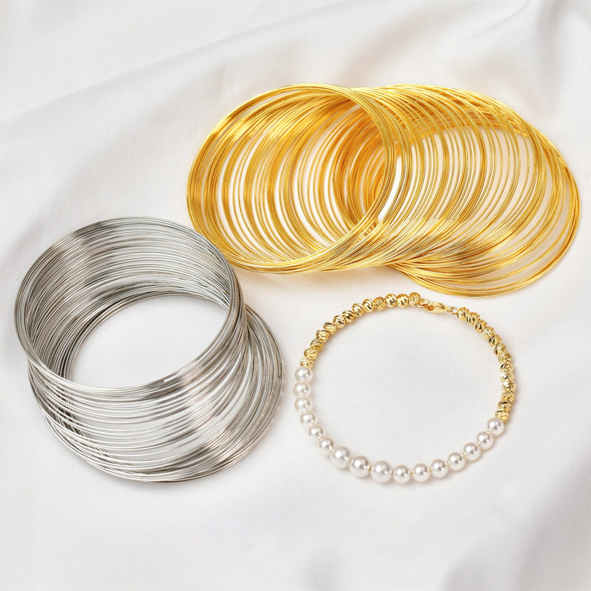 Gold-tone and silver-tone memory wire coils beside a beaded bracelet example