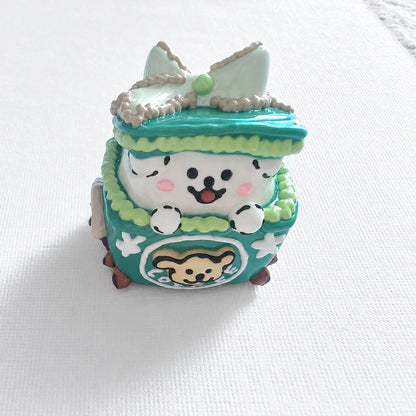 Single hand-painted teal acrylic bead shaped like a gift box with a spotted puppy face and cream bow.