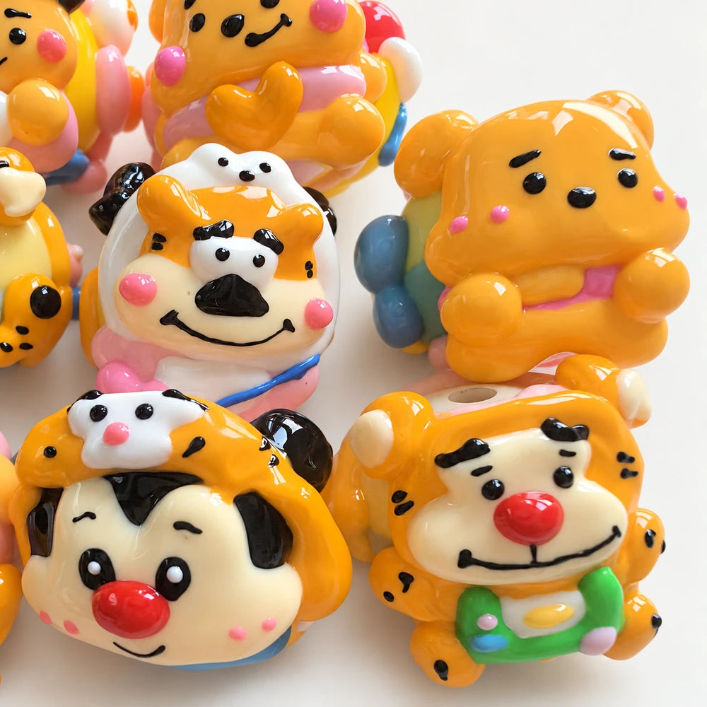 Close-up of glossy orange and yellow bead faces with hand-painted eyes, cheeks and three-dimensional details.