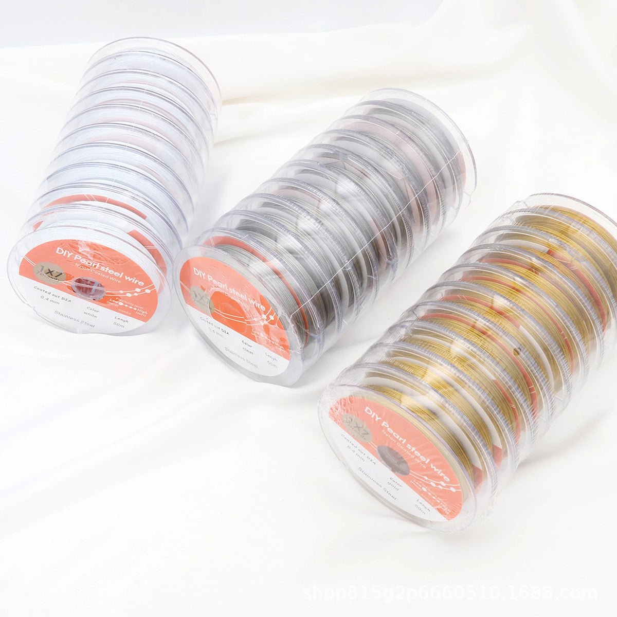 Rows of individually packaged white, steel-colored and gold-tone beading wire; each purchase is one selected spool.