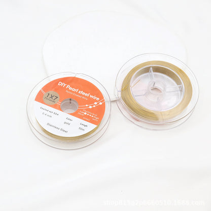 Gold-tone nylon-coated beading wire shown from both sides in its clear spool packaging.