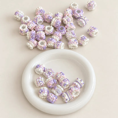 Close-up of lavender purple, pink and cream raised floral handmade beads with through holes