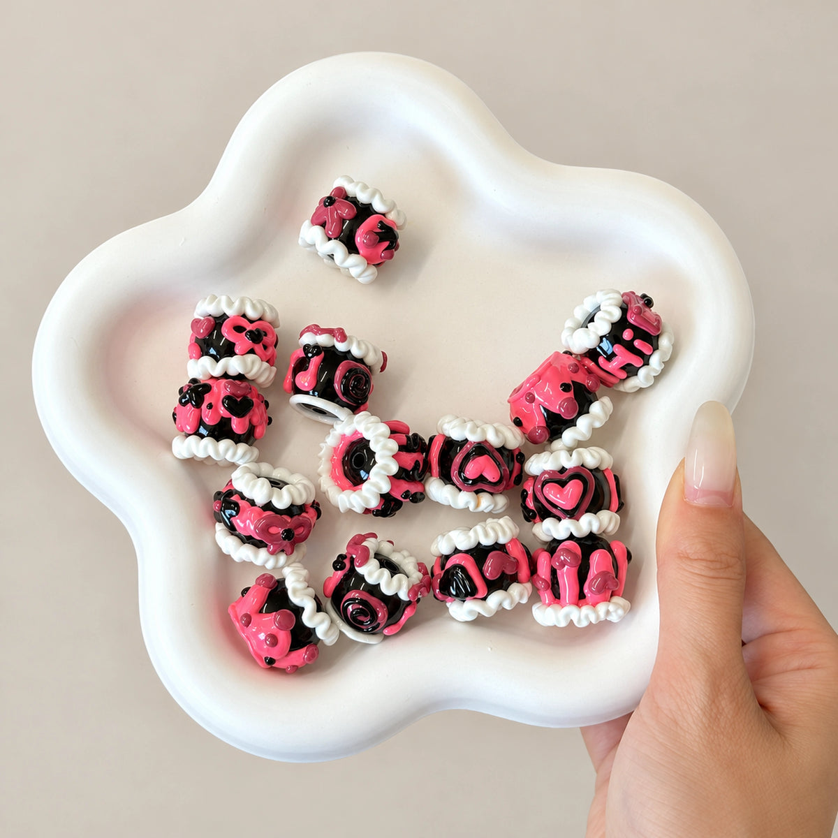Pink and black hand-painted statement beads showing detailed raised decoration and center holes