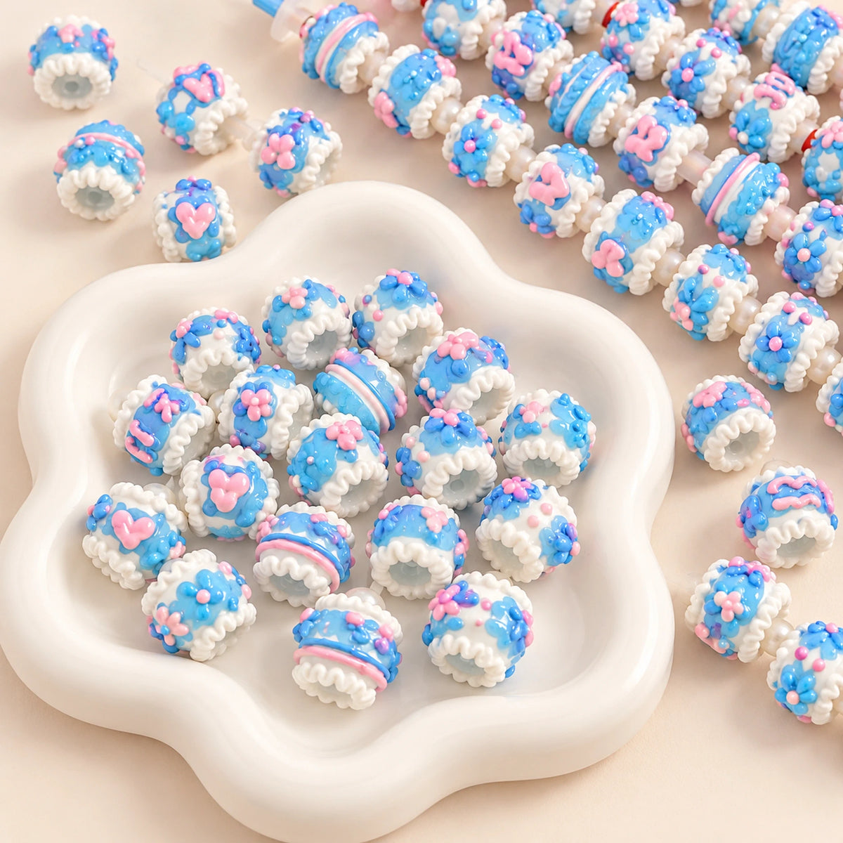 Close-up of blue jelly textured and white hand-painted beads with glossy pink flowers and through holes