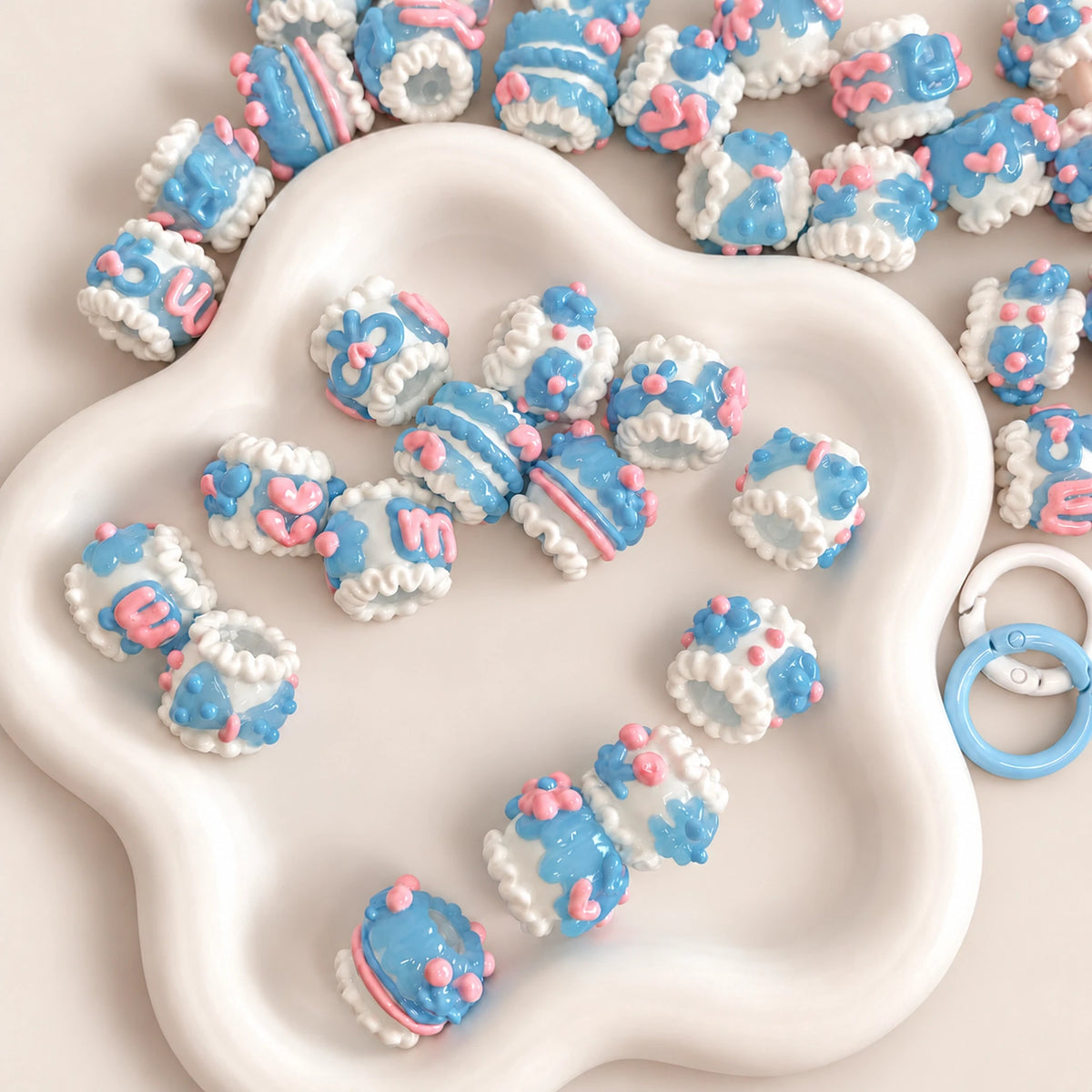 Translucent blue jelly and white hand-painted 3D beads with pastel pink flowers in a white decorative bowl